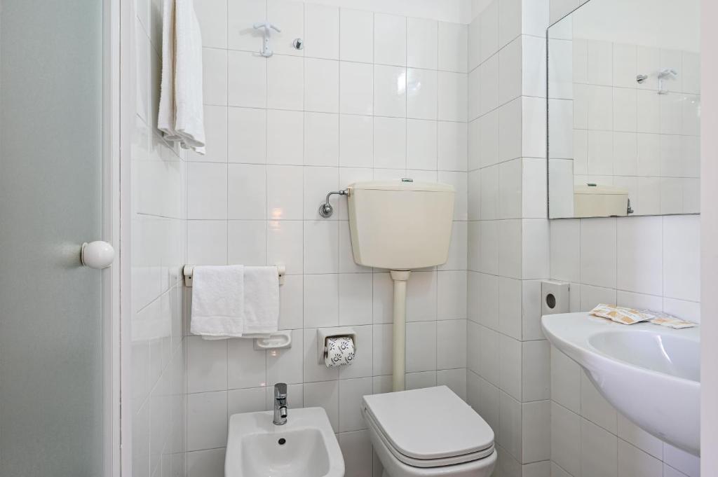 une salle de bain blanche avec toilettes et lavabo dans l'établissement Amadei Hotel Promenade, à Pesaro 28 autres photos