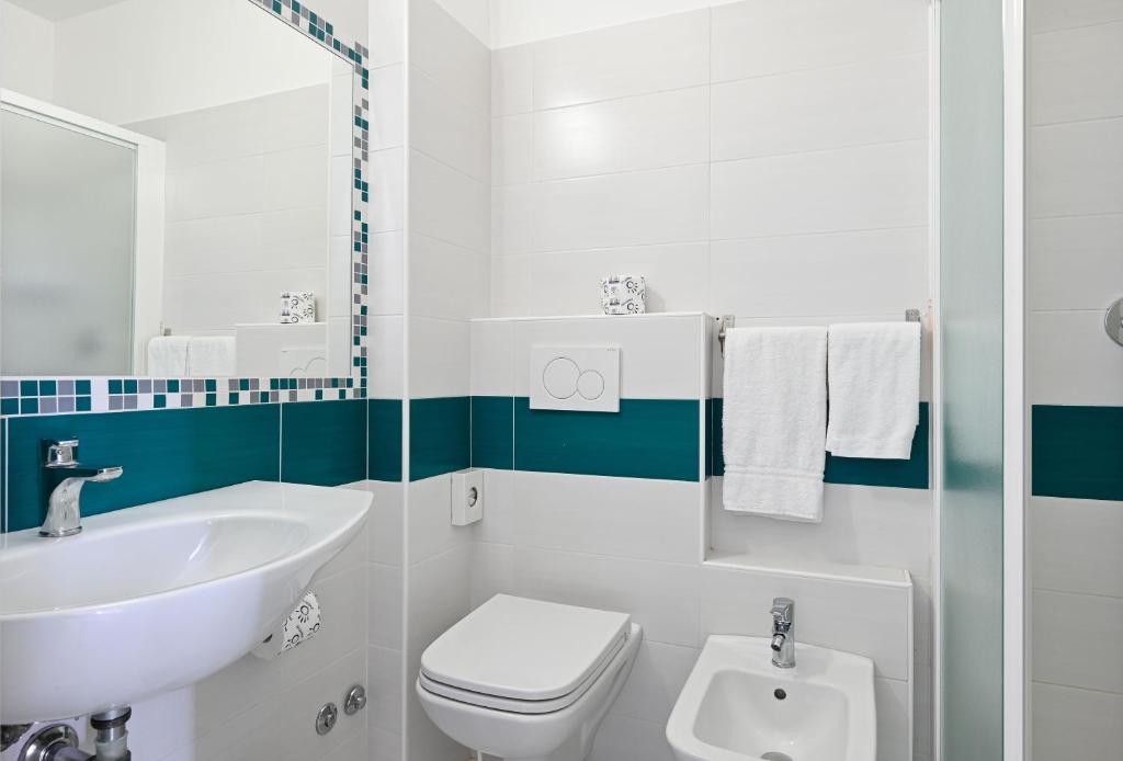 une salle de bain blanche avec un lavabo et des toilettes dans l'établissement Amadei Hotel Promenade, à Pesaro