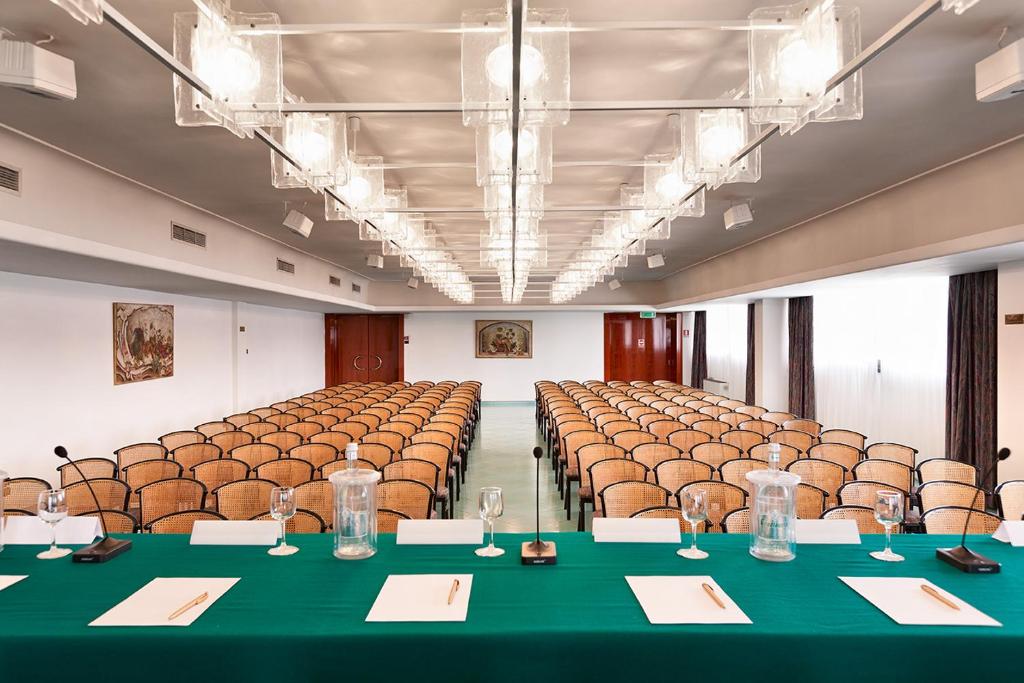 une grande chambre avec des chaises et des tables. dans l'établissement Grand Hotel Terme, à Margherita di Savoia 56 autres photos