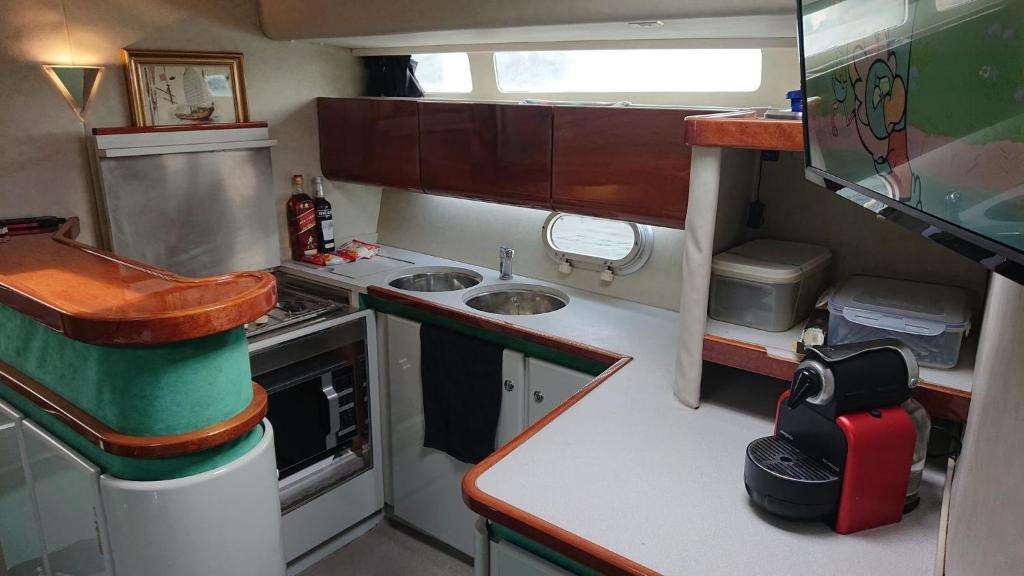 une petite cuisine avec un évier et une cuisinière dans l'établissement Le For Sea, au Barcarès