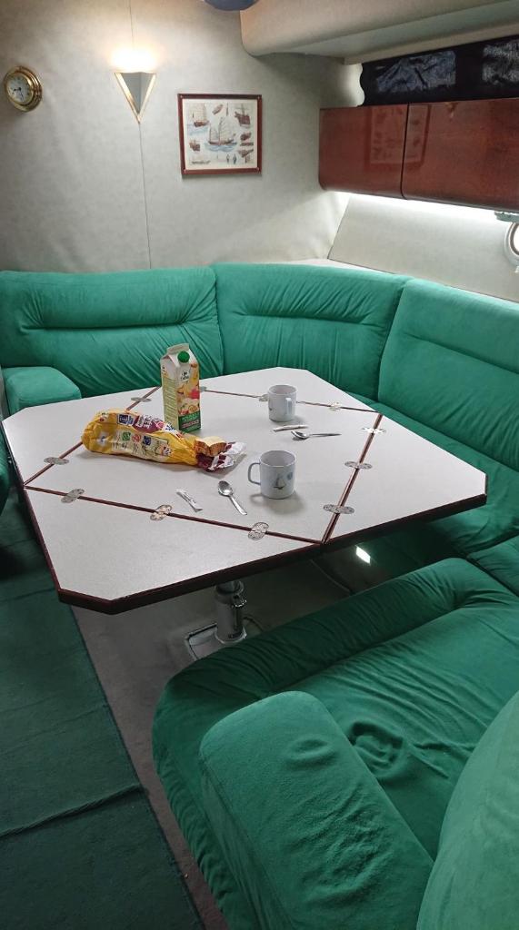 - un canapé vert avec une table et des tasses dans l'établissement Le For Sea, au Barcarès 1 autre photo