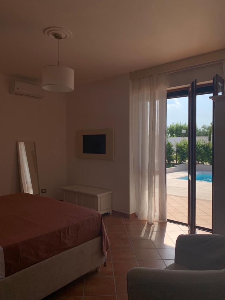 une chambre avec un lit et une porte coulissante en verre dans l'établissement Relais Gregorio 2, à Paternopoli