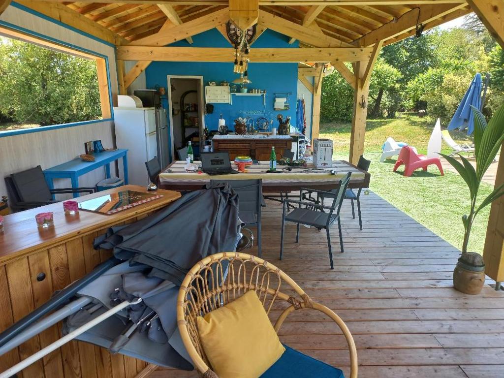 une terrasse avec une table et des chaises dans une maison dans l'établissement Les chalets Salinéens, à Salies-du-Salat
