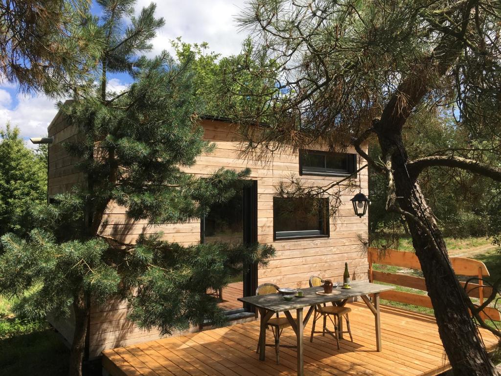 une petite maison avec une table sur une terrasse dans l'établissement La pause tiny, à Ploërmel