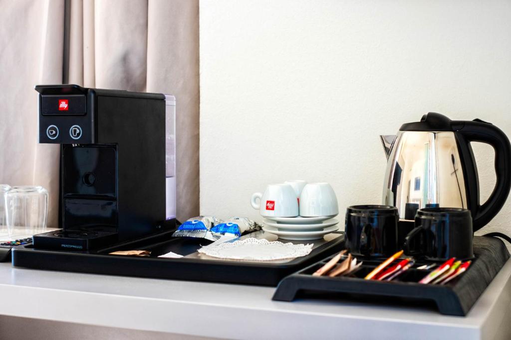 un comptoir avec une cafetière et des tasses dessus dans l'établissement Hotel Petit Palais, sur le Lido de Venise