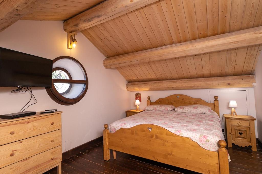 - une chambre avec un lit en bois et une télévision dans l'établissement La dimora del verde con piscina, à Nicolosi 90 autres photos