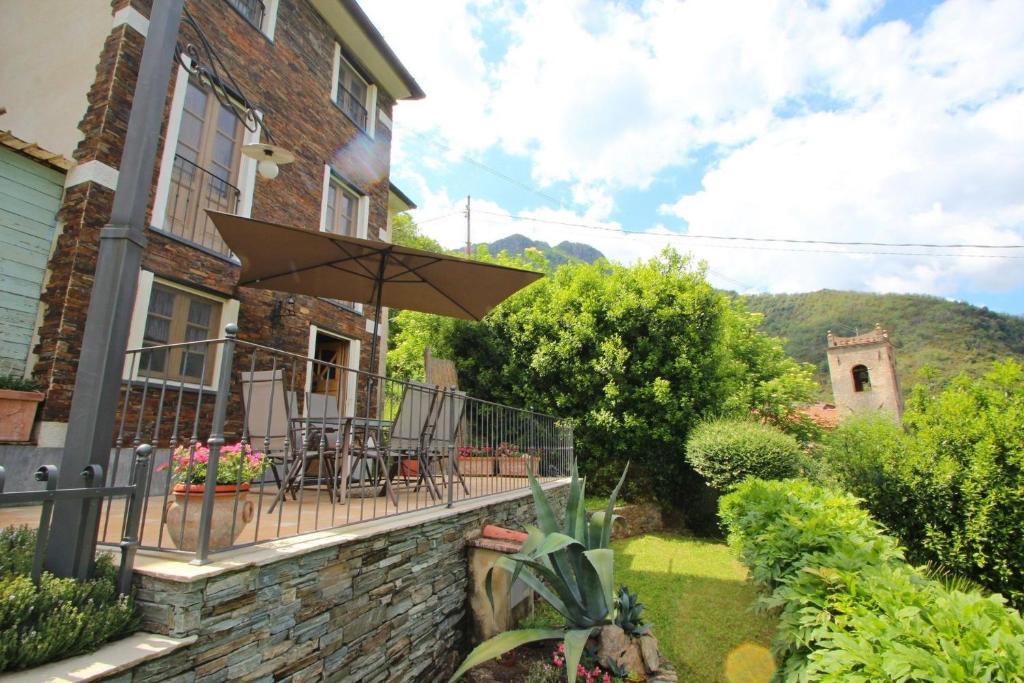 Cette maison dispose d'un balcon avec des chaises et un parasol. dans l'établissement IL PICCOLO PARADISO, à Seravezza