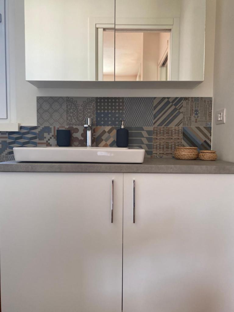 une cuisine avec des armoires blanches et un évier dans l'établissement Villa Lena, à Camaiore