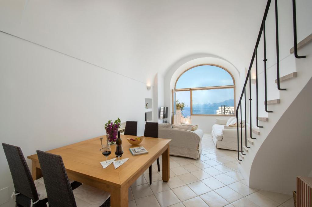 une salle à manger avec une table et un salon dans l'établissement Seventh Heaven Praiano, à Praiano