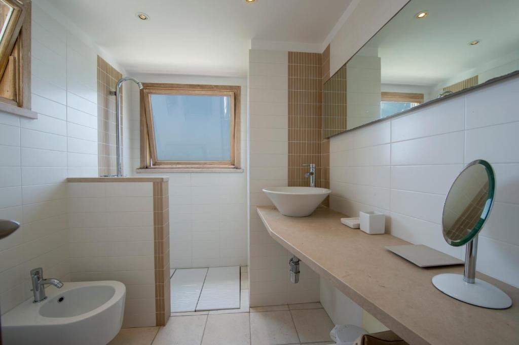 une salle de bain blanche avec un lavabo et un miroir dans l'établissement Seventh Heaven Praiano, à Praiano 40 autres photos