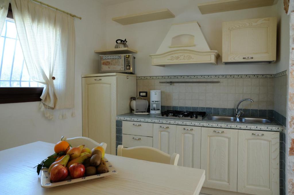 une cuisine avec une table avec un bol de fruits dessus dans l'établissement Il borgodellequerce CASA ULIVI PISCINA PRIVATA, à Martina Franca