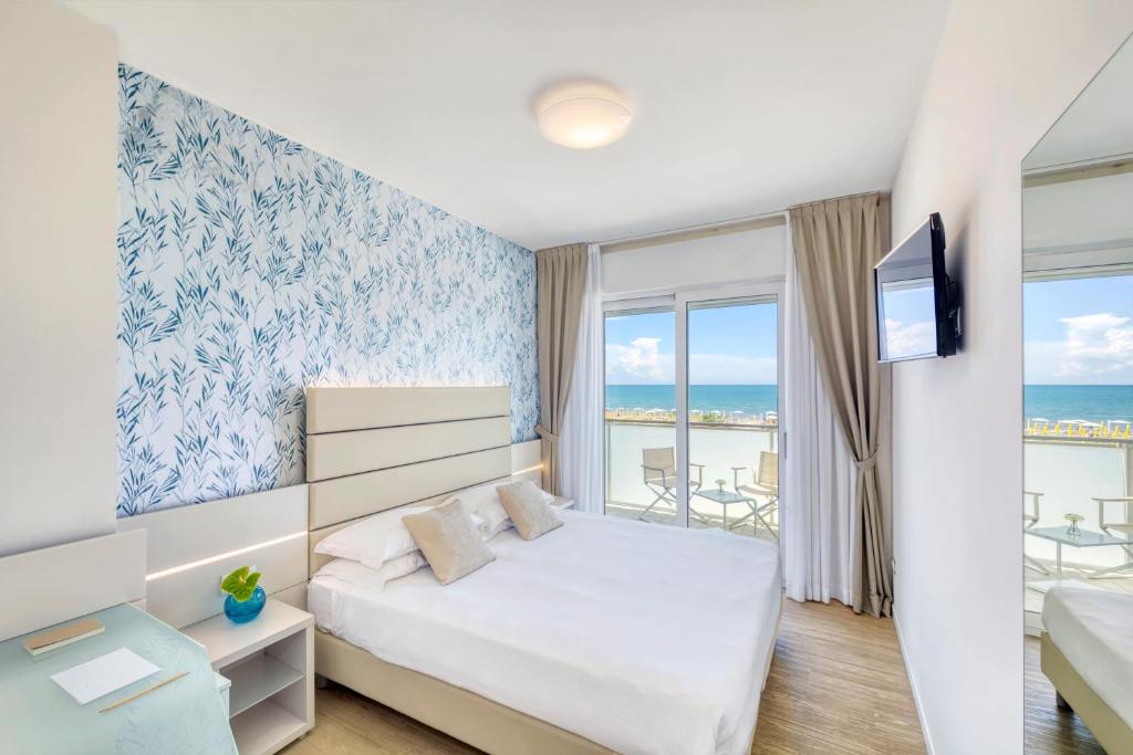 une chambre avec un lit et une vue sur l'océan dans l'établissement Hotel Astoria, à Caorle
