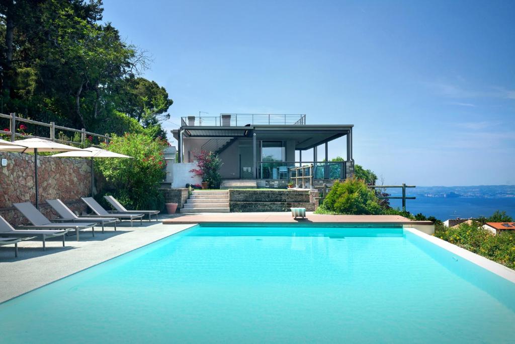 une piscine avec des chaises et une maison dans l'établissement Villa GEMMMA With Pool, à Torri del Benaco