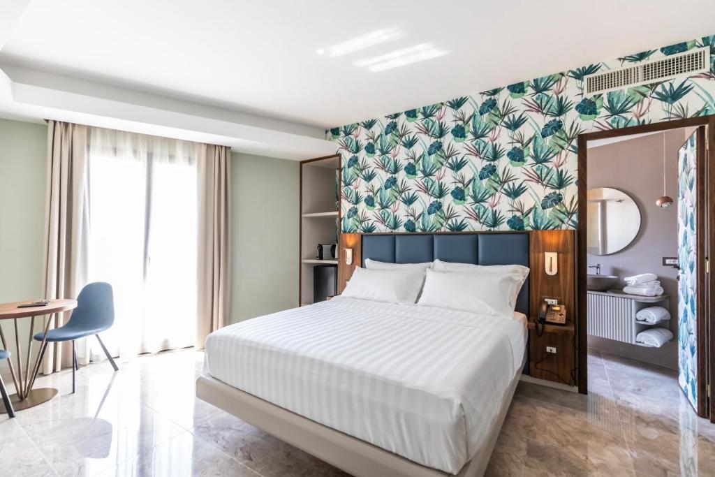 une chambre avec un grand lit avec un mur végétal dans l'établissement SOLMARIS TROPEA City Center - Rooms & Suites - Private Parking, à Tropea
