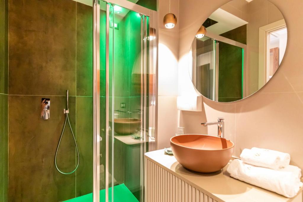 La salle de bains est pourvue d'un lavabo et d'une douche. dans l'établissement SOLMARIS TROPEA City Center - Rooms & Suites - Private Parking, à Tropea