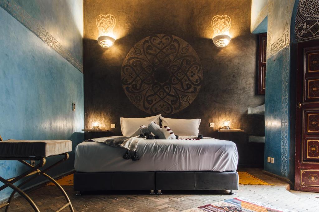 - une chambre avec un lit avec un grand orb sur le mur dans l'établissement La Casa Ysabella, à Marrakech