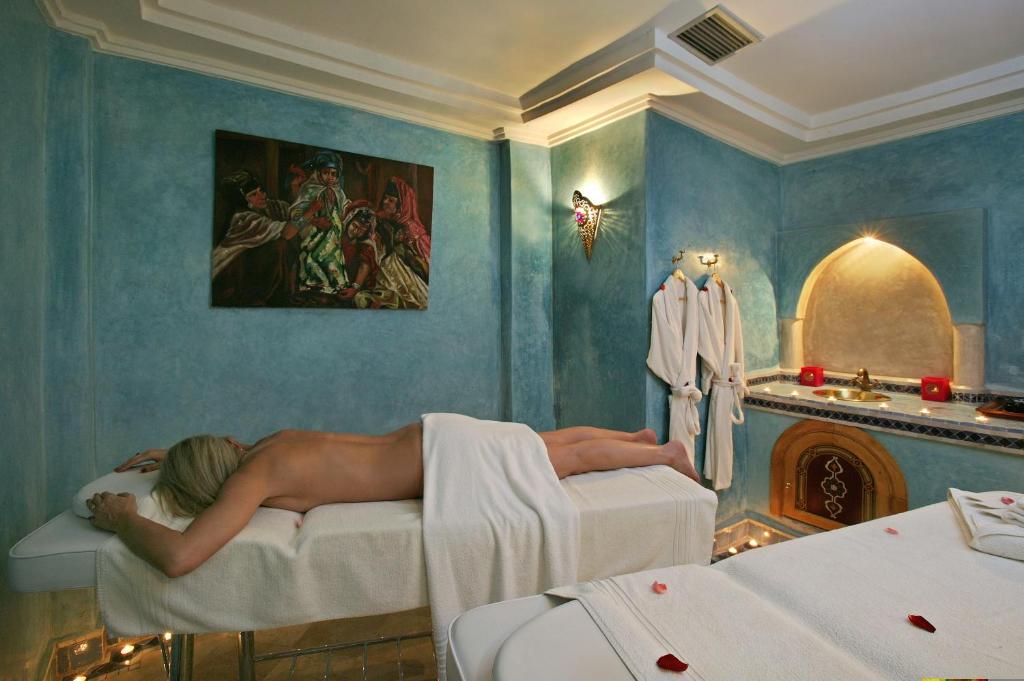 Une femme nue dormant sur un lit dans une pièce dans l'établissement Riad & Spa Esprit Du Maroc, à Marrakech