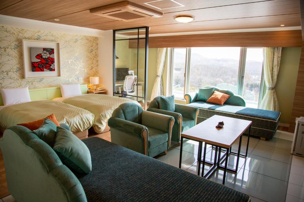 Cette chambre comprend deux lits, un canapé et une table. dans l'établissement Shiretoko Daiichi Hotel, à Shari 124 autres photos