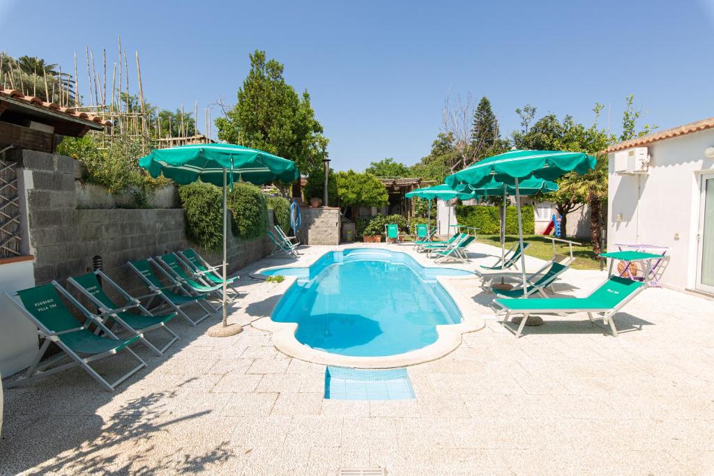 une piscine avec chaises et parasols dans l'établissement Residence Villa Tina, à Ischia
