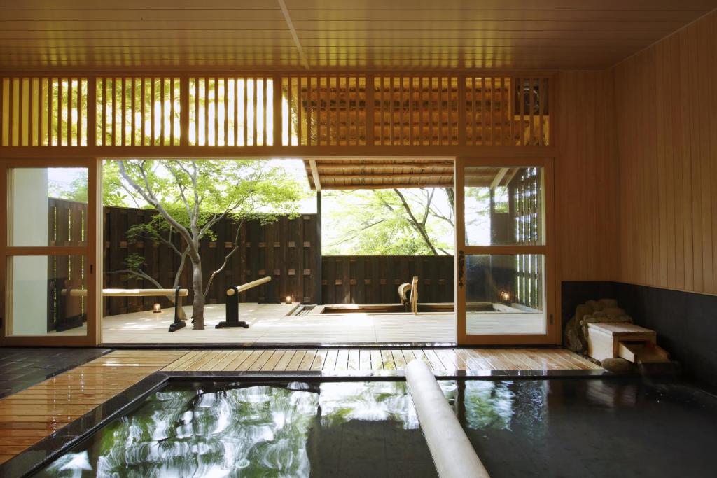 - une piscine dans une maison avec une grande fenêtre dans l'établissement Negiya Ryofukaku, à Kobe