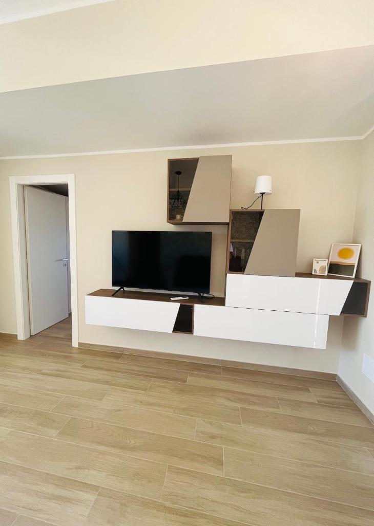 un salon avec une télévision sur un mur dans l'établissement Villa Lombardo Luxury, à Balestrate