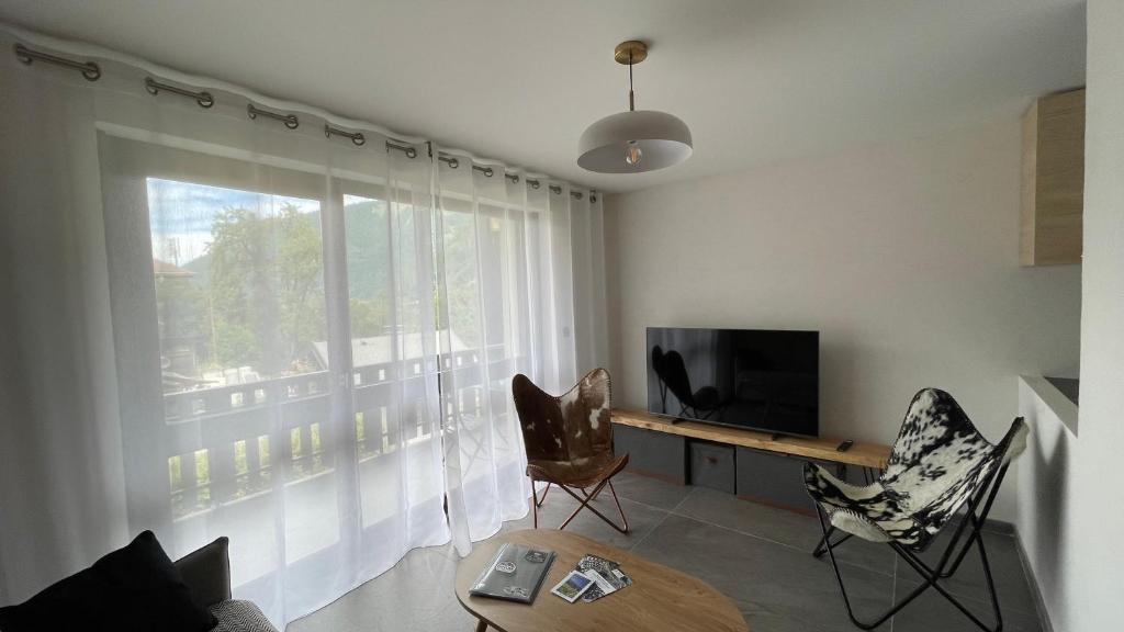 un salon avec une télévision et une fenêtre dans l'établissement Morzine : bel appartement à 5 mn du téléphérique, à Morzine