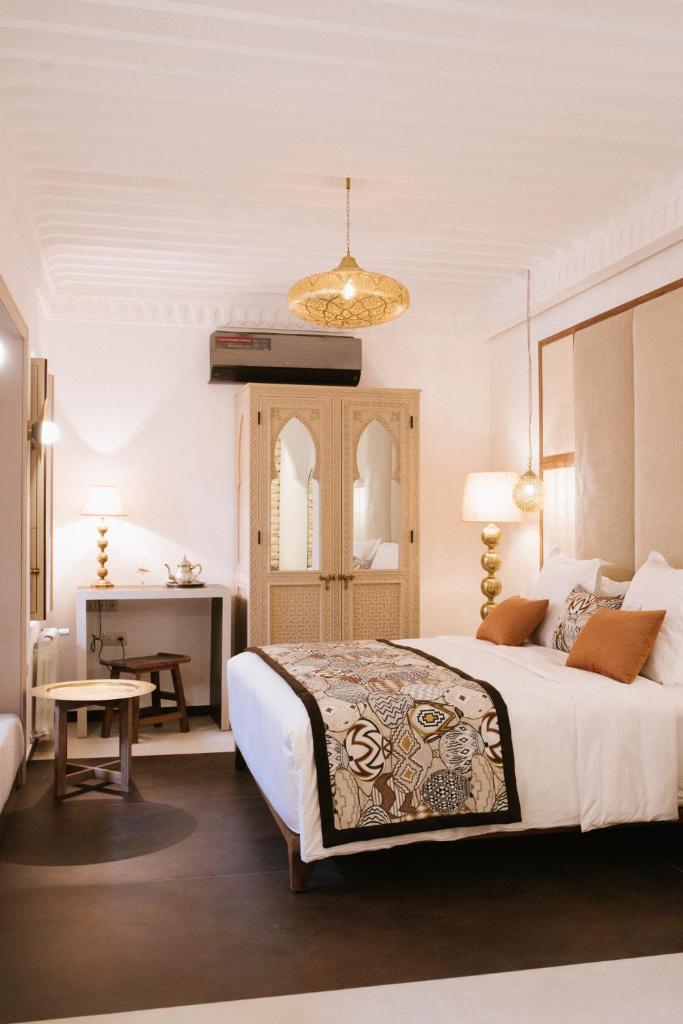 une chambre avec un grand lit et un bureau dans l'établissement Riad Nyla Wellness and Spa, à Marrakech