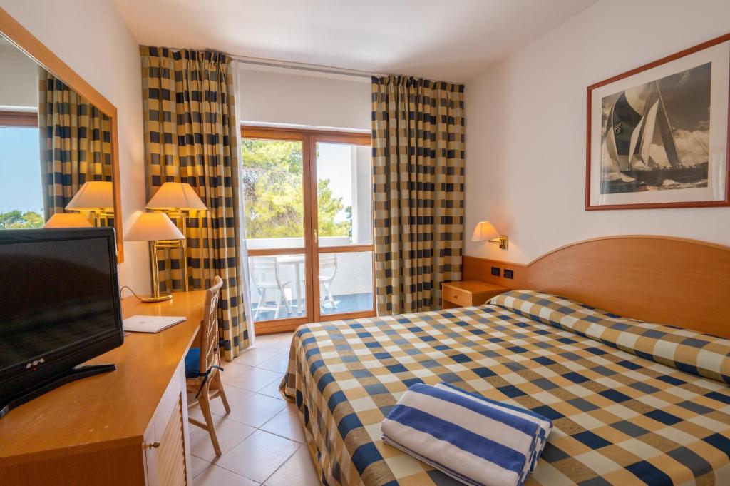 une chambre d'hôtel avec un lit et une télévision dans l'établissement Pizzomunno Vieste Palace Hotel, à Vieste