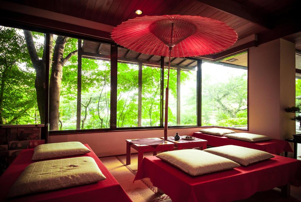 Cette chambre comprend deux lits et une grande fenêtre. dans l'établissement 료칸 여명 旅館 黎明 Ryokan Reimei, à Yufu