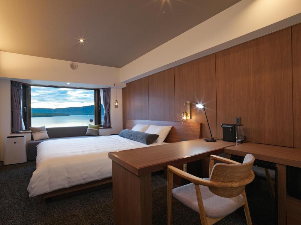 une chambre d'hôtel avec un lit et un bureau avec un bureau dans l'établissement THE FOREST AKAN Tsuruga Resort, à Akankohan 37 autres photos