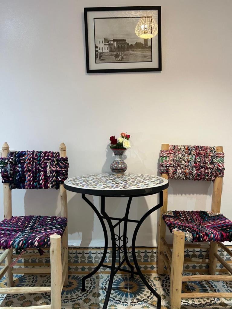 une table avec deux chaises et une table avec un vase dans l'établissement Riad Moroccan Style, à Fès