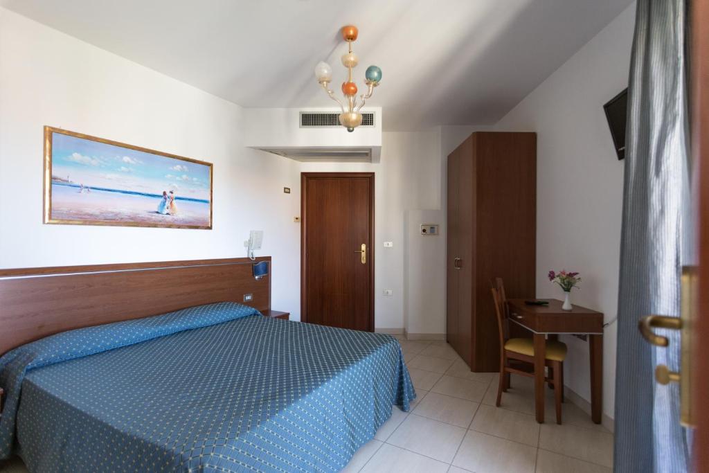 une chambre avec un lit bleu, une table et une chaise dans l'établissement Hotel Abruzzo, à Pineto 44 autres photos