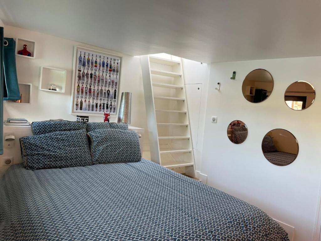 une chambre avec un lit et des miroirs au mur dans l'établissement Péniche "SunFlower", à Paris