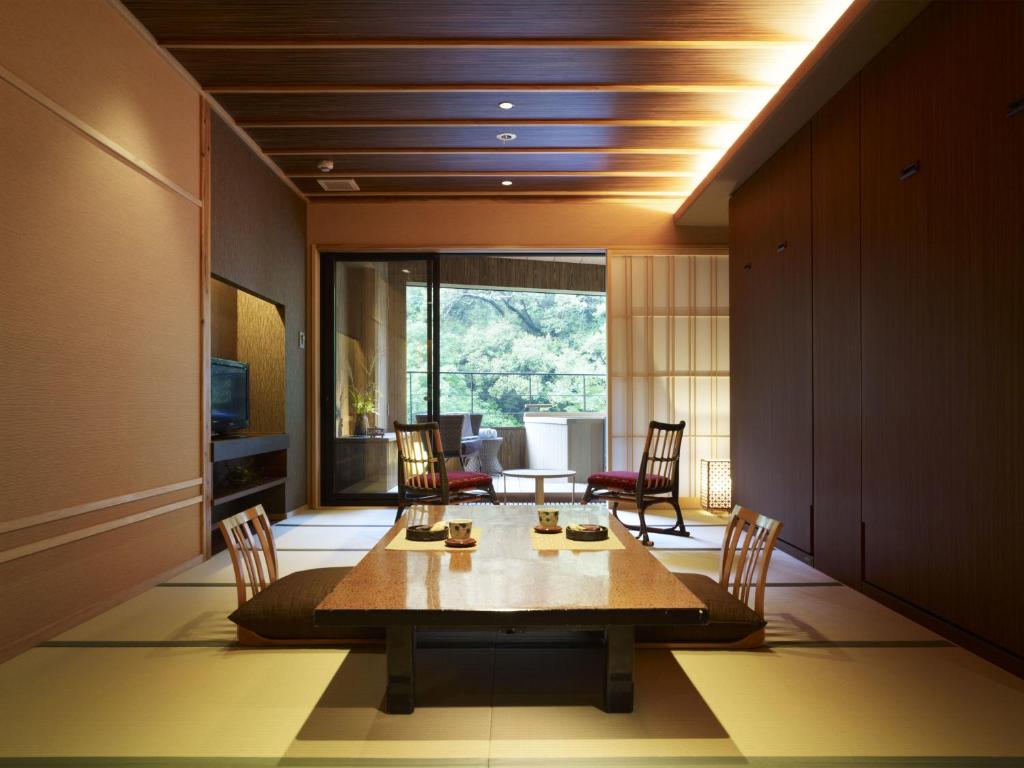 une salle à manger avec une table et des chaises dans l'établissement Fudoguchikan, à Izumi-Sano