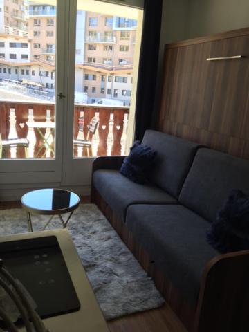 un salon avec un canapé et une grande fenêtre dans l'établissement studio cabine chalet club III entièrement rénové, à Tignes