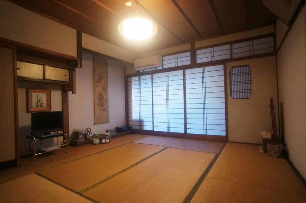 une chambre vide avec une grande fenêtre et une grande porte dans l'établissement Ougiya Ryokan, à Toyooka 17 autres photos