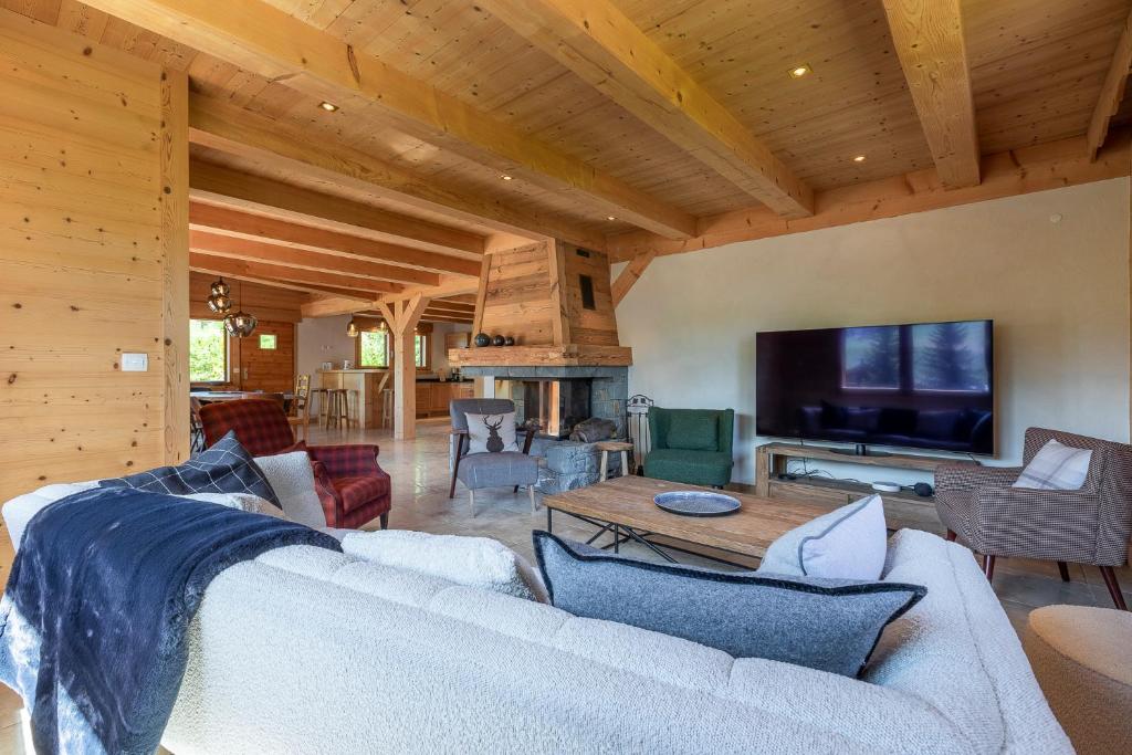 un salon avec un canapé et une télévision dans l'établissement Chalet Les Bognettes 10 personnes, au Grand-Bornand