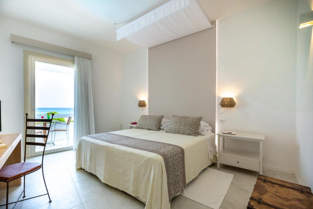 une chambre avec un lit avec vue sur l'océan dans l'établissement Hotel Flamingo, à Santa Margherita di Pula