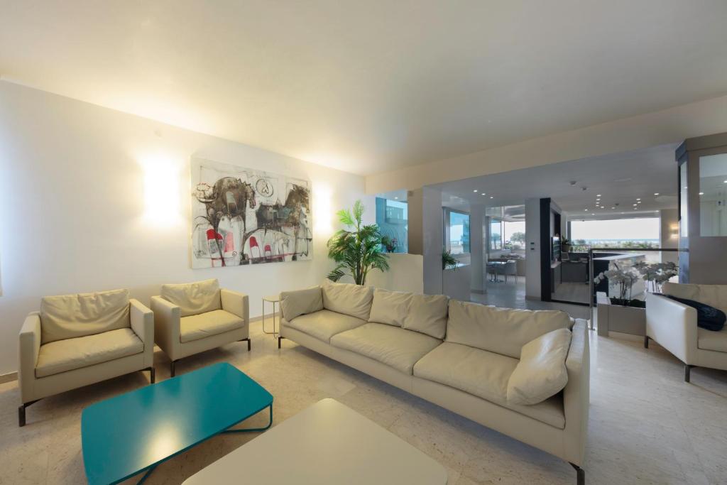 un salon avec un canapé et deux chaises dans l'établissement Hotel Monaco, à Caorle