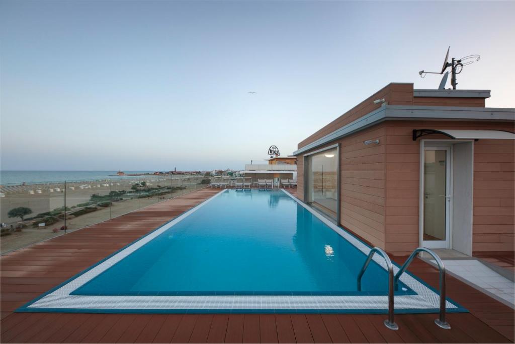 une piscine sur le toit d'un immeuble dans l'établissement Hotel Monaco, à Caorle