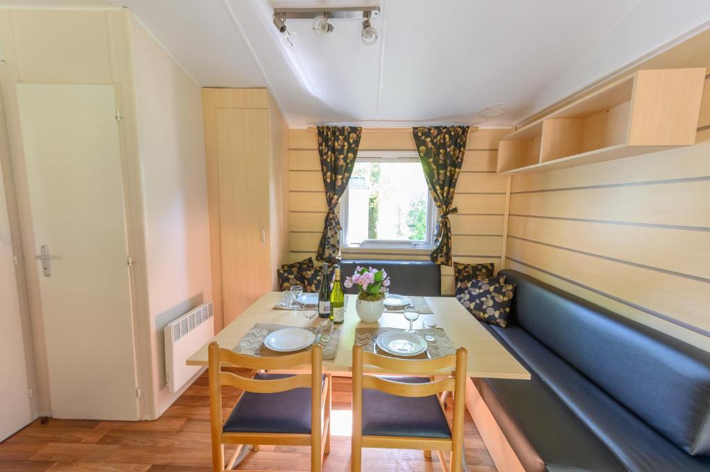 une petite salle à manger avec une table et des chaises dans l'établissement Mobil-home LE WILSON, à Mirgaudon