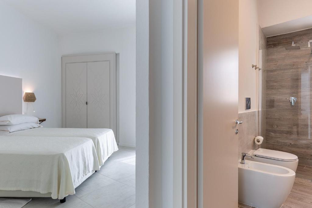 une chambre avec un lit et une salle de bain avec WC dans l'établissement Hotel Flamingo, à Santa Margherita di Pula