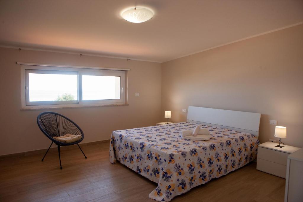 une chambre avec un lit, une fenêtre et une chaise dans l'établissement Villa Lombardo Luxury, à Balestrate