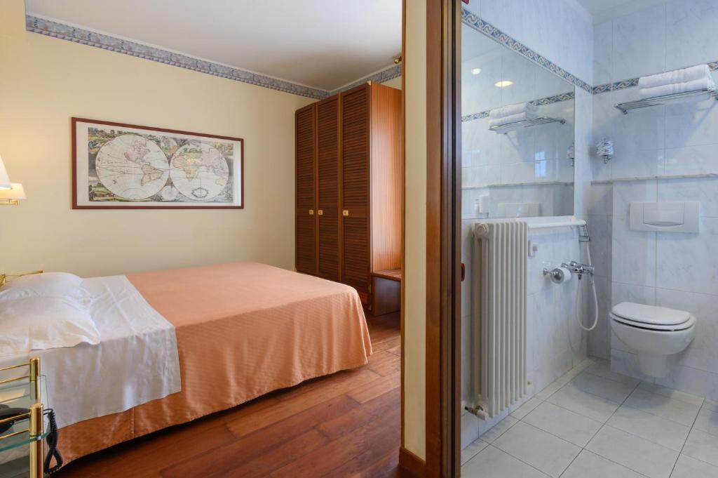 - une chambre avec un lit, une douche et des toilettes dans l'établissement Atilius Hotel & Suites, à Riccione