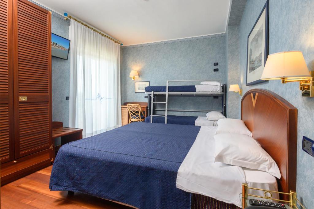 - une chambre avec un lit bleu et des oreillers blancs dans l'établissement Atilius Hotel & Suites, à Riccione