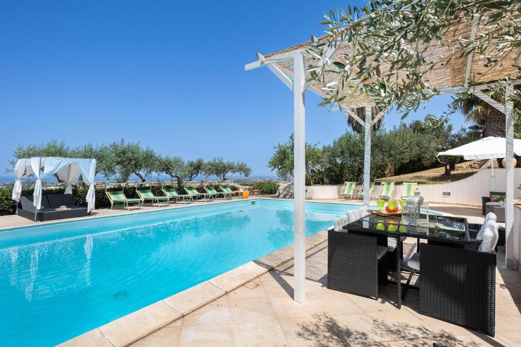 une image d'une piscine avec une table et des chaises dans l'établissement Villa Sunrise Palm, à Marsala