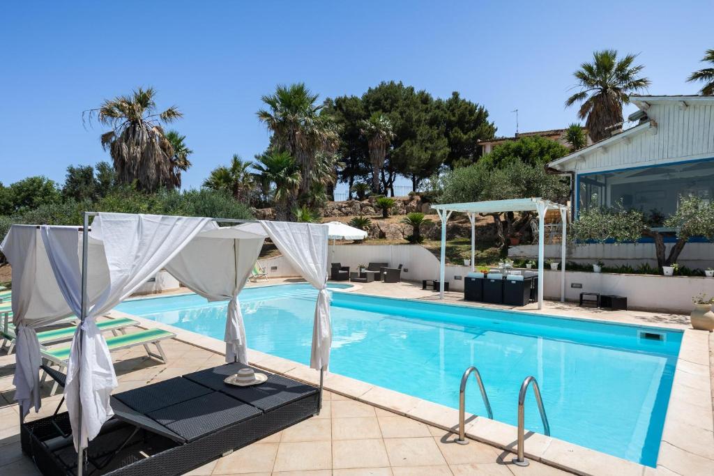 - une piscine avec une chaise et une table à côté d'une maison dans l'établissement Villa Sunrise Palm, à Marsala