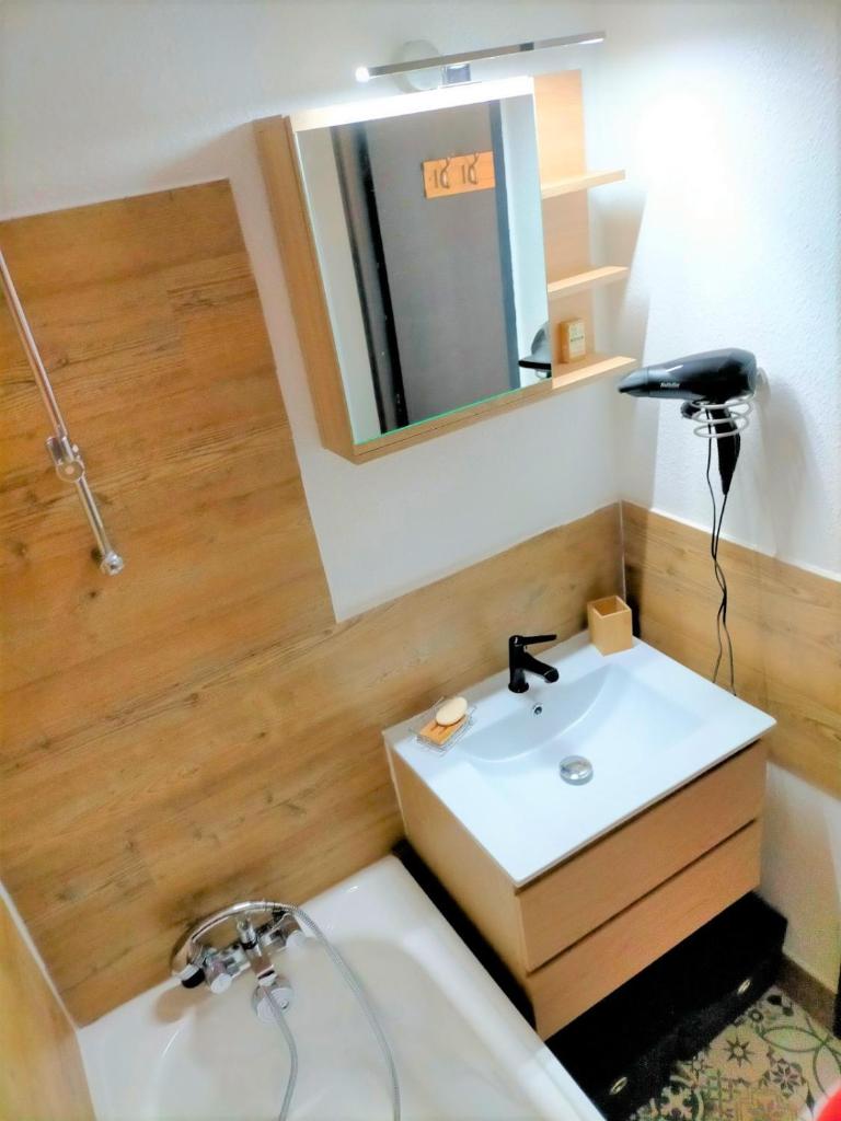 une salle de bain avec un lavabo et un miroir dans l'établissement Valfrejus Studio 19m2 cosy 60 m des pistes draps non compris, à Modane