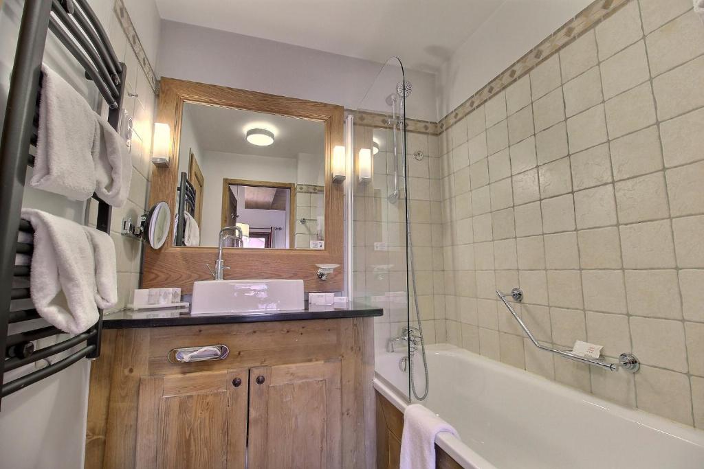 une salle de bain avec une baignoire, un lavabo et une douche dans l'établissement ARC 1950 - Suite de Prestige - Cheminée intérieur, à Arc 1950