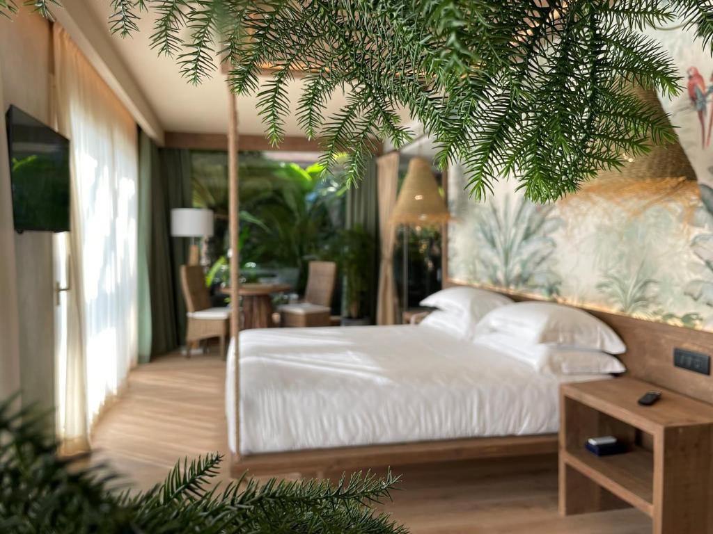 une chambre avec un lit blanc et une table dans l'établissement AQA Palace, à Caorle 81 autres photos